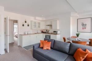 a living room with a couch and a kitchen at Frankie Says - London lodgings don't get more fabulous than the Fitz n' Glamour, a dazzling 1 BR apartment in central Fitzrovia in London