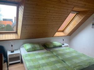 1 dormitorio con 1 cama y 2 ventanas en Strandnahes-Ferienhaus-Nessmersiel, en Nessmersiel