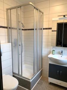 y baño con ducha y lavamanos. en Strandnahes-Ferienhaus-Nessmersiel, en Nessmersiel