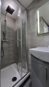 a bathroom with a shower and a sink at Argyle Square Hotel in London