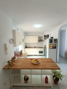 una cocina con una mesa con un bol de fruta. en Casita La Ballena Tenerife Sur en Playa de San Juan