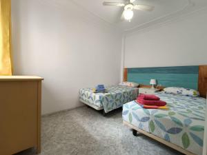 1 dormitorio con 2 camas y ventilador de techo en Casita La Ballena Tenerife Sur en Playa de San Juan