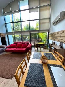 uma grande sala de estar com um sofá vermelho e uma mesa em Arrábida Resort em Quinta do Anjo