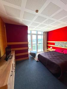 a bedroom with a bed and a red wall at Arrábida Resort in Quinta do Anjo