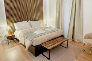 een slaapkamer met een groot bed met een tafel bij Minerva Boutique Residence in Rome
