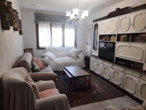 a living room with couches and a chandelier at CASA JUNTO AL PARQUE NATURAL DE LAS BARDENAS in Sádaba
