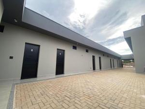 a large white building with black doors on it at Village Prime Hotel in Miguelópolis