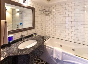 a bathroom with a sink and a bath tub at Mene City Hotel in Antalya