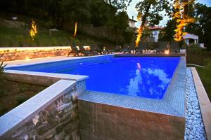 a swimming pool in a backyard at night at Villa Ariston in Opatija