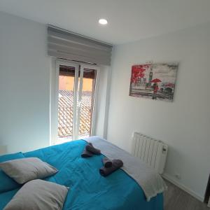 a bedroom with a blue bed and a window at Apartament al cor de Begur in Begur