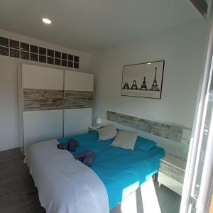 a bedroom with two beds with blue sheets at Apartament al cor de Begur in Begur