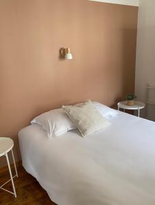 a bedroom with a white bed with two tables at HOTEL de la PLAGE in Wissant