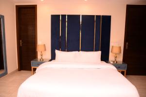 - une chambre avec un grand lit blanc et 2 tables dans l'établissement Tom's Luxury, à Peshawar