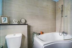 ein Badezimmer mit einer weißen Badewanne und einem WC in der Unterkunft Spa Shower I 4Bed 3Bath I Sleeps x9 I Parking x2 in Elstree