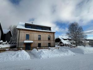 a building with snow in front of it at Helly - Kvilda - apartmány in Kvilda