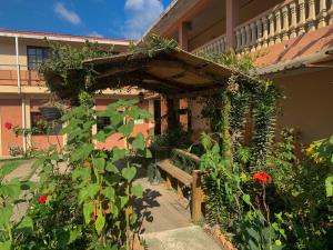 een tuin met een bank voor een gebouw bij Apart-Hotel Plaza Familiar in La Esperanza