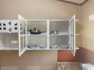 uma cozinha com armários brancos com pratos em Apart-Hotel Plaza Familiar em La Esperanza