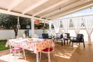 patio con tavolo e tovaglia rosa di Hostly - Giusy Garden Suite a Capannoli