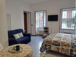 uma sala de estar com uma cama e um sofá azul em LATTE E MIELE em Stresa