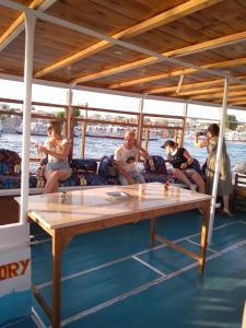 a group of people sitting around a table on a boat at الاقصر in Luxor