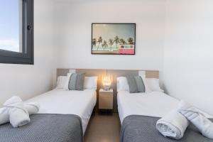 two beds in a room with a picture on the wall at Arenales Bahia Penthouse in Arenales del Sol +43 photos