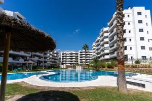 a swimming pool in front of a large apartment building at Arenales Bahia Penthouse in Arenales del Sol
