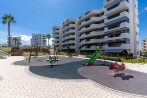a playground in front of a large apartment building at Arenales Bahia Penthouse in Arenales del Sol