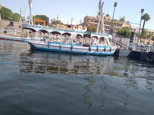 a blue boat is docked in the water at الاقصر in Luxor