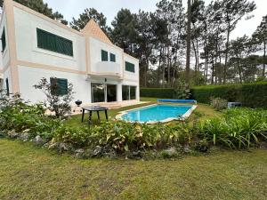 a house with a swimming pool in the yard at Golf, Pool and Beach Aroeira Villa in Aroeira