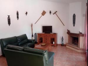 sala de estar con sofá, TV y chimenea en Chalet con piscina privada en Conil Solo Familias, en Conil de la Frontera