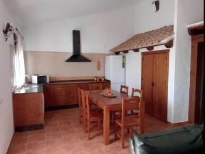 cocina y comedor con mesa y sillas en Chalet con piscina privada en Conil Solo Familias, en Conil de la Frontera