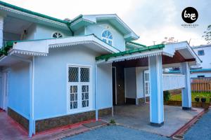 a blue house with a large front porch at Raala Nuwara Eliya Hotel & Resort in Nuwara Eliya