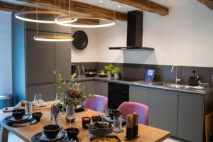 een keuken met een houten tafel en stoelen en een keuken met een aanrecht bij Chalet Weidehaus De Luxe 