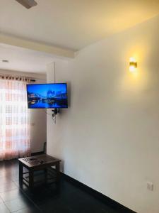 a living room with a flat screen tv on the wall at SK Villa in Galle