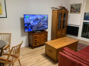 uma sala de estar com uma televisão de ecrã plano numa cómoda em Apartament Retro Bolesławiec em Bolesławiec