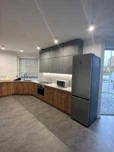 a kitchen with a stainless steel refrigerator and wooden cabinets at Noclegi Pniów 51 