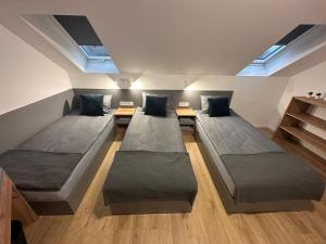 a room with three beds in it with skylights at Noclegi Pniów 51 