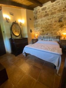 a bedroom with a bed and a stone wall at seaside suite in paradise in Santuario di Gibilmanna