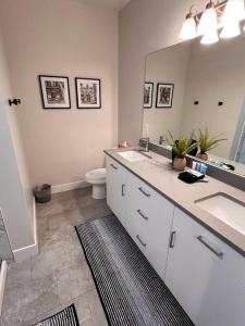a bathroom with two sinks and a toilet and a mirror at Richfield Loft Suite - Castle Rock Condos in Richfield