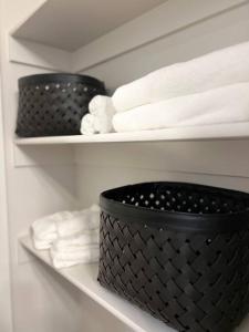 a shelf with two black baskets and white towels at Richfield Loft Suite - Castle Rock Condos in Richfield