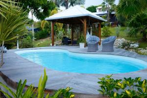 a swimming pool in a yard with a gazebo at Résidence Mapou : Bungalow Cycas - logement de charme avec piscine in Saint-François