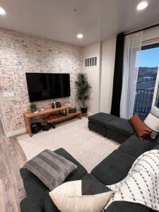 een woonkamer met een bank en een flatscreen-tv bij Richfield Loft Suite - Castle Rock Condos in Richfield