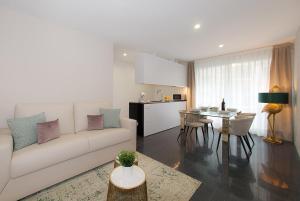 a living room with a white couch and a table at Holihome Rambla 24 in Alicante