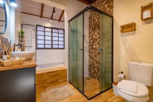 a bathroom with a shower and a toilet and a sink at Pousada Vila 505 in Canela +161 photos