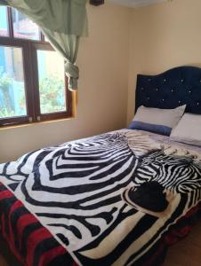 Una manta de cebra en una cama en un dormitorio en Casa Abuelito's Andean Haven, en Huaraz