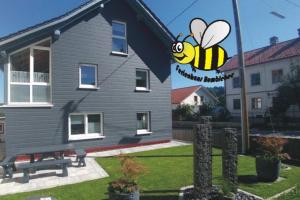 Una casa con una abeja pintada a un lado. en Ferienhaus Bumblebee im Allgäu en Eggenthal
