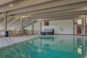 - une piscine avec des chaises dans un bâtiment dans l'établissement Sleepless in Snowood, à Thornton