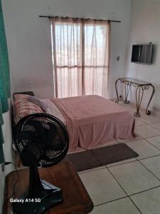 - une chambre avec un lit et un ventilateur sur une table dans l'établissement Kit com varanda, à São Paulo