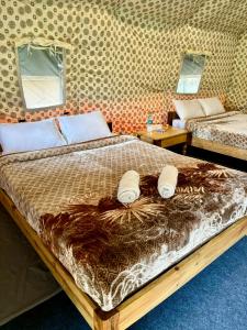 a bedroom with two beds in a room at Kodom Bari Retreat, Kaziranga in Kāziranga