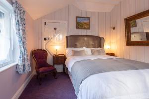 een slaapkamer met een groot bed en een stoel bij Frogs Hall B&B in Eye